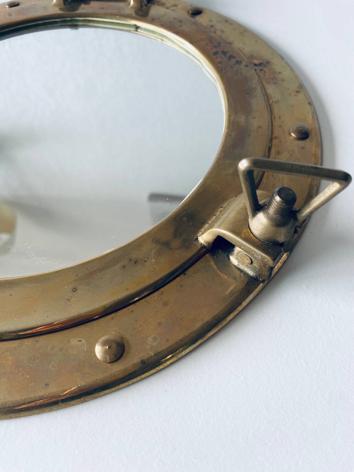 Porthole mirror in gilded brass