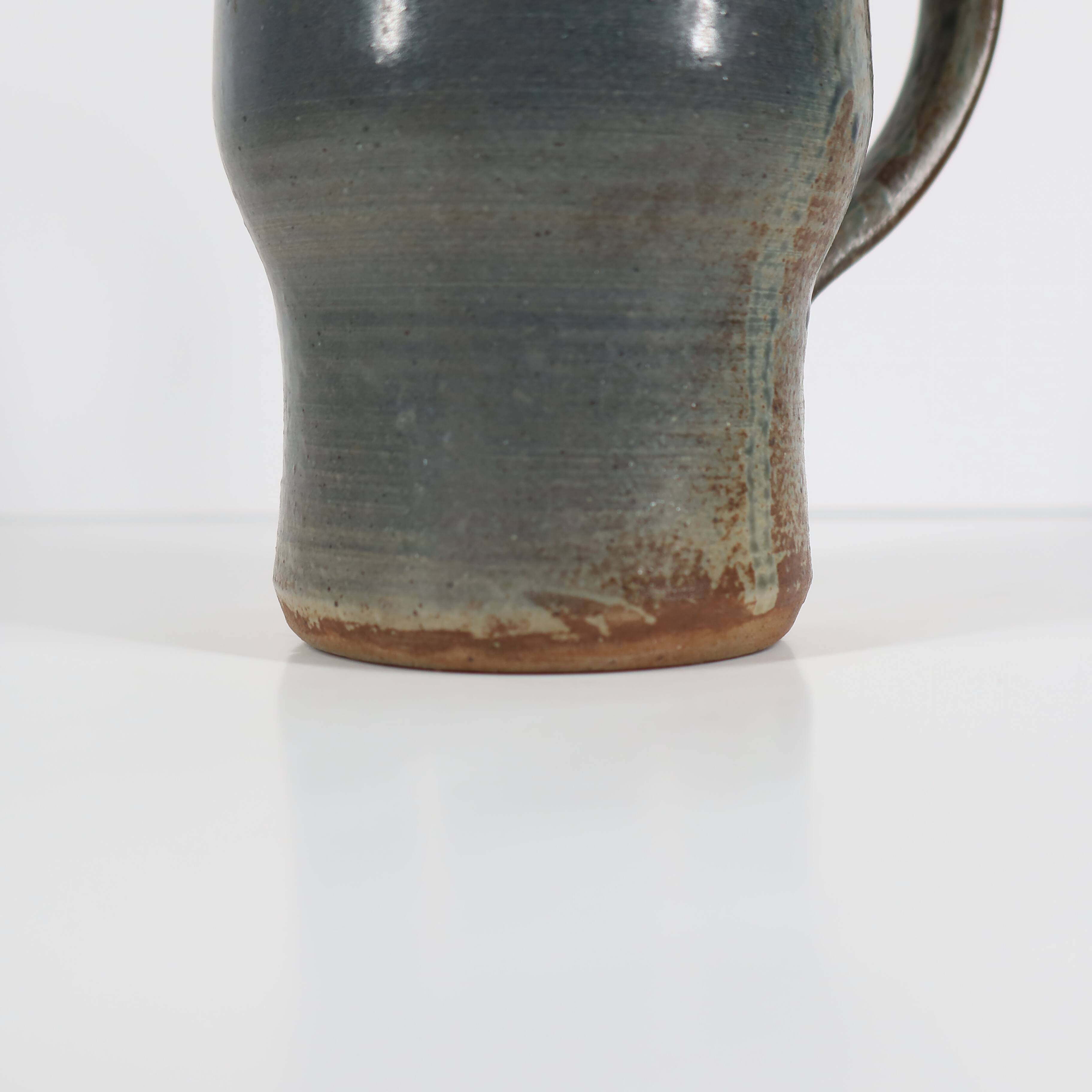 Handcrafted stoneware pitcher with blue-green hues, signed piece