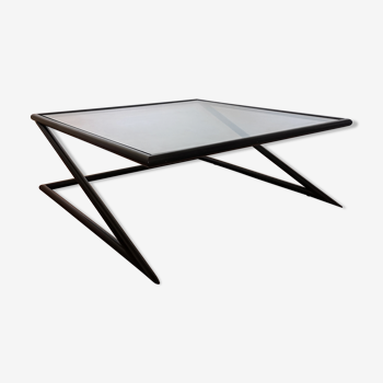 Table basse moderniste avec son dessus en verre carré et ses structures en métal noir