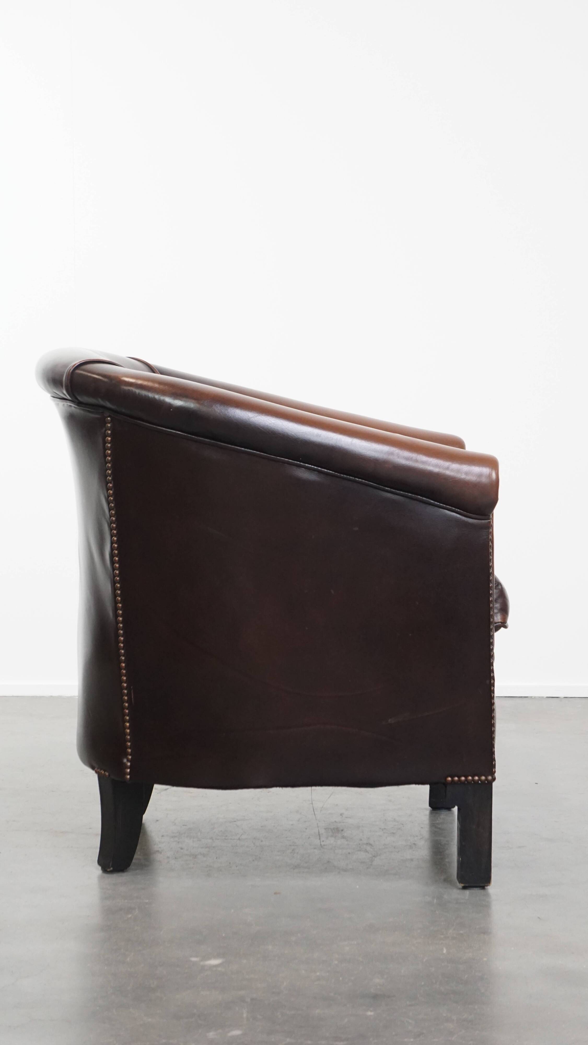 Fauteuil club de couleur foncée en cuir de vachette