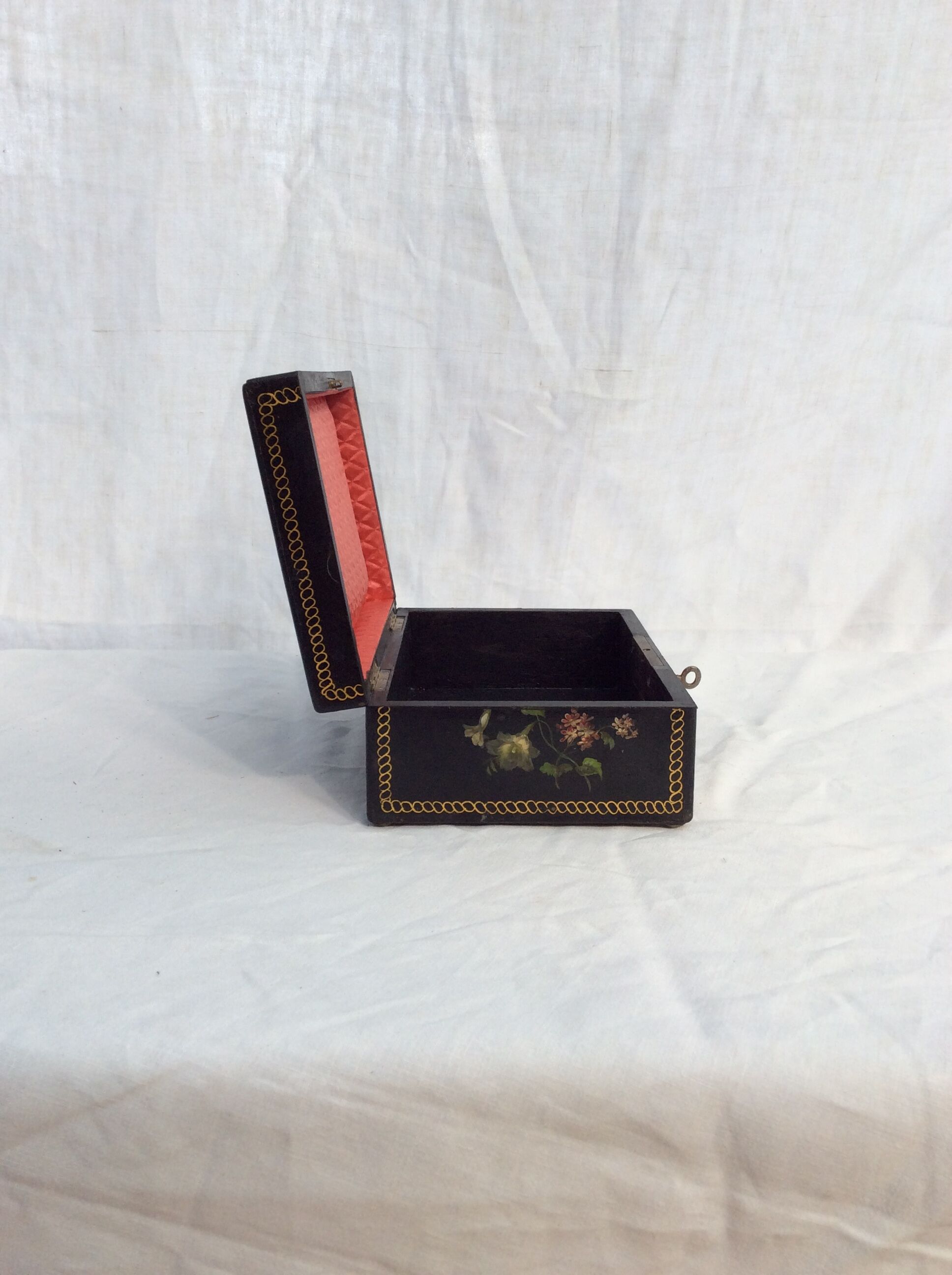 Old black wooden box adorned with roses with keys