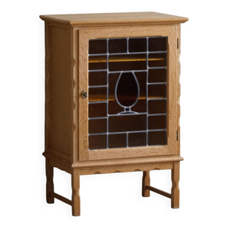 Scandinavian wardrobe in natural oak with a glass front.