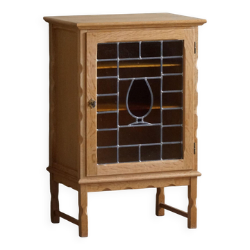 Scandinavian wardrobe in natural oak with a glass front.
