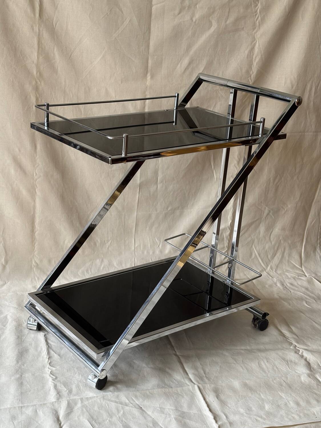 Modernist serving trolley in chromed metal and black smoked glass
