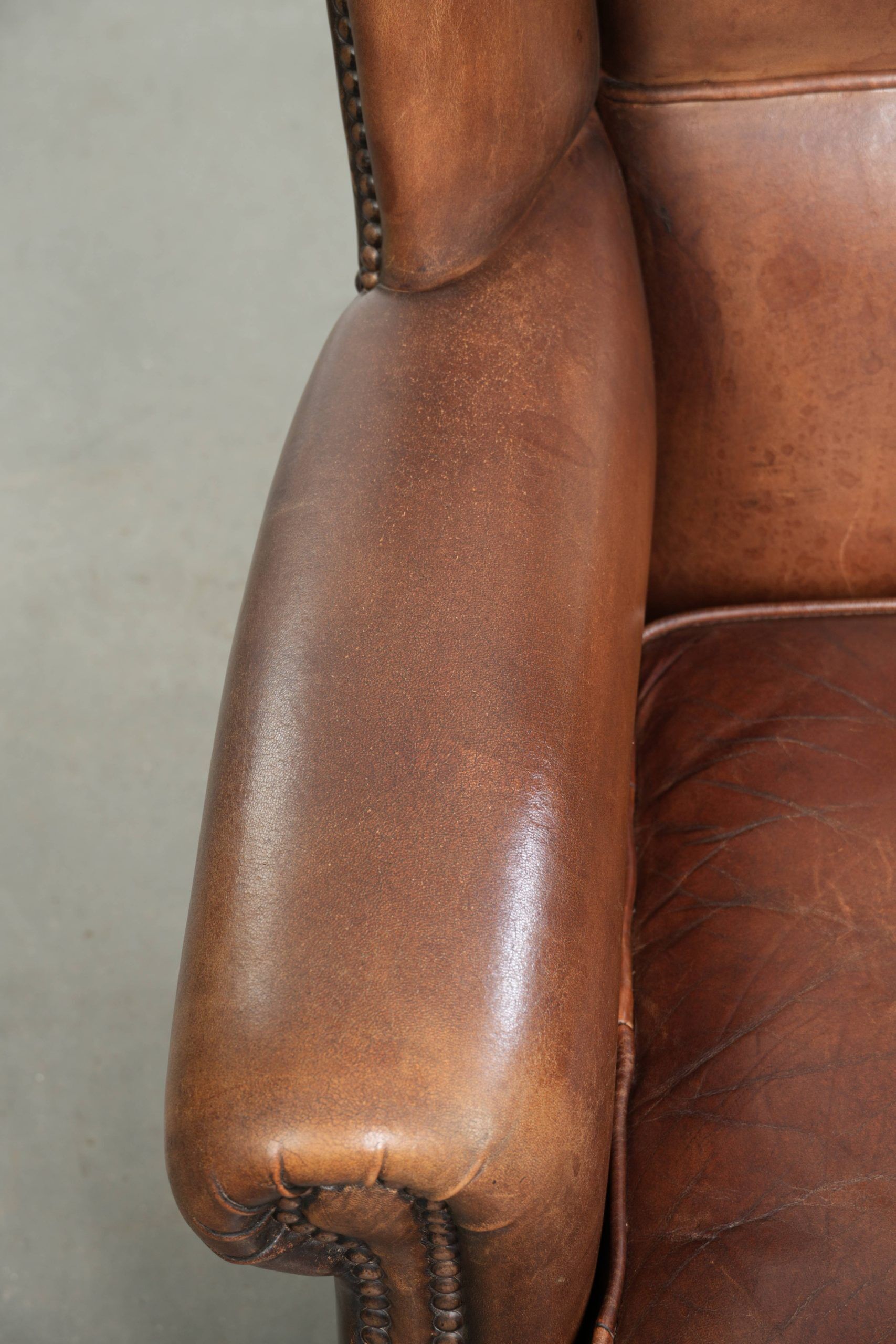 Subtle dark brown sheepskin wingback armchair with a timeless look subtle