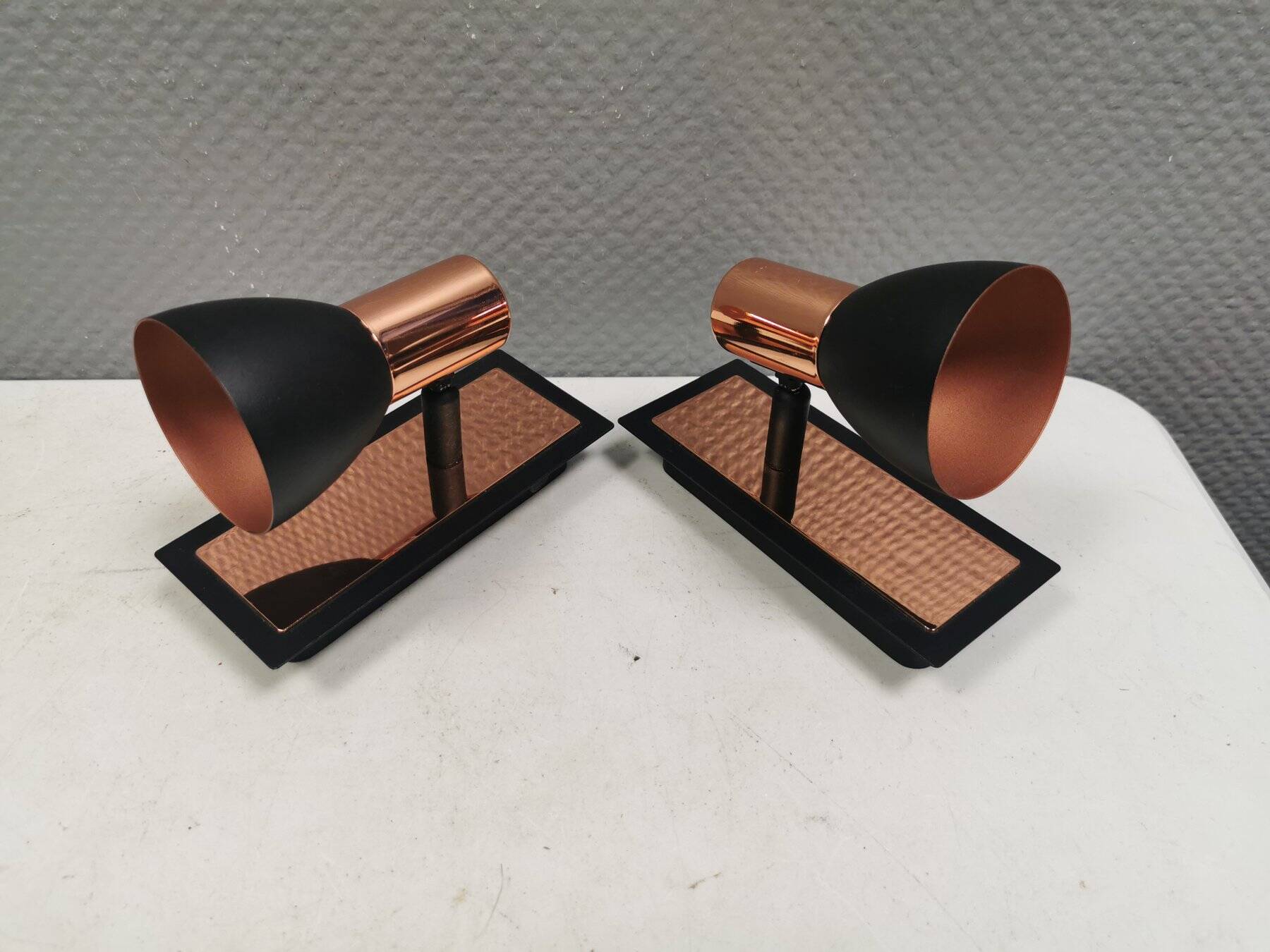 A pair of wall lamps from Eglo, in copper color and black.