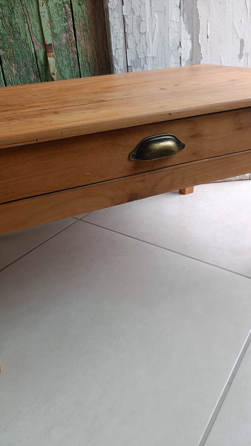 Coffee table with raw wood and a large drawer.