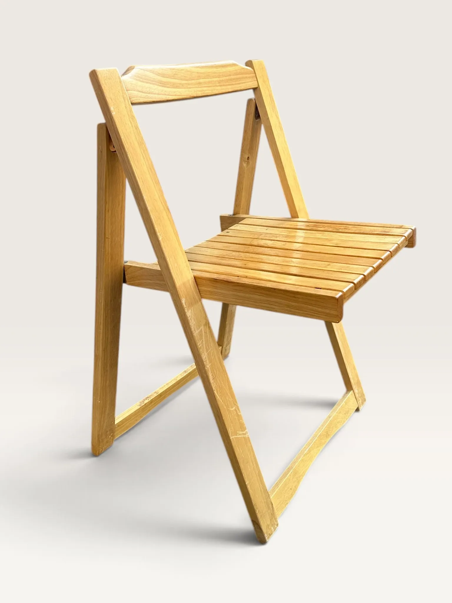 Blonde wooden folding chair in the style of Aldo Jacober.