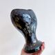 Black ceramic vase with a woman's face.