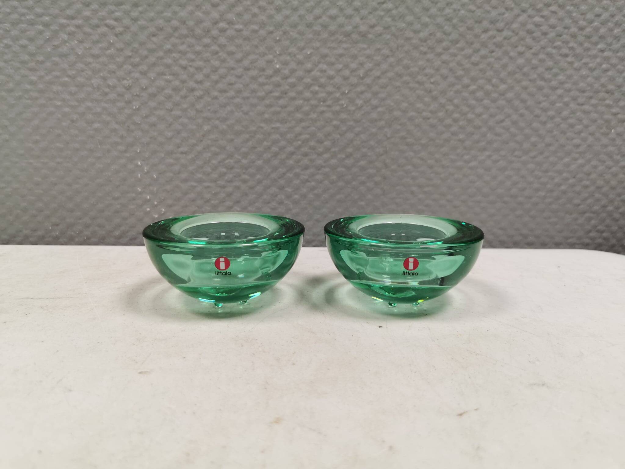 A set of iitalla candle holders in green transparent glass.