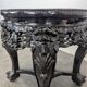 Side table with a wooden frame and marble top.