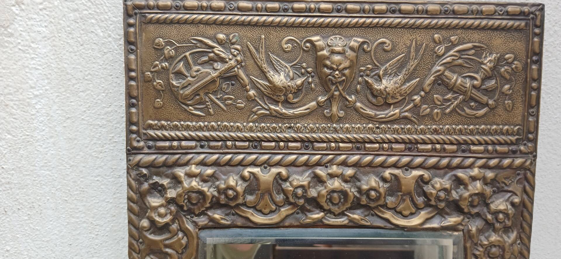 Bevelled mirror from the 1930s in repoussé brass.