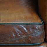 Sheepskin leather armchair in a cognac color with black piping