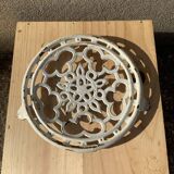 Old trivet in enameled cast iron round format white vintage tableware