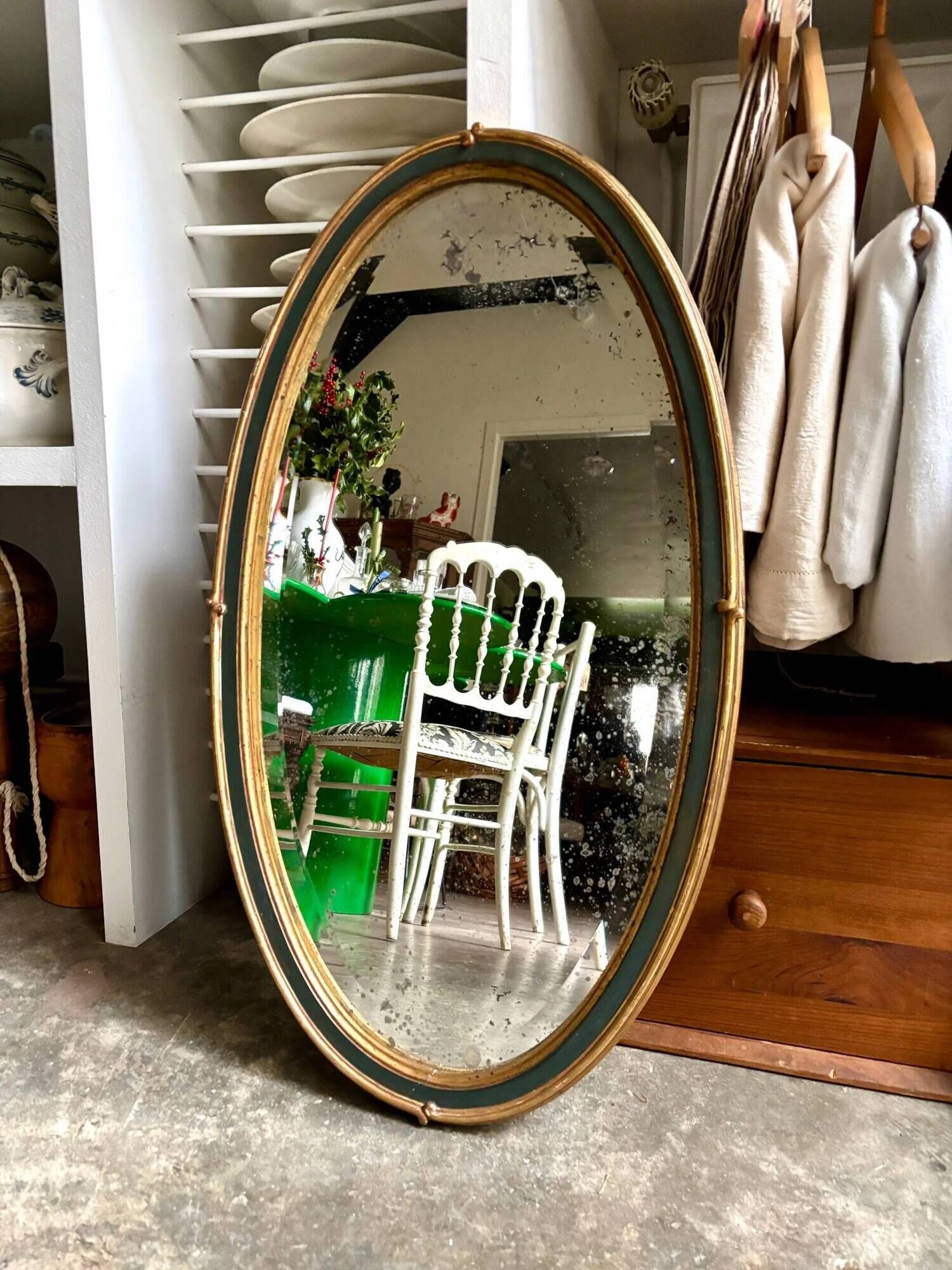 Oval mirror in wood and green and gold stucco, 75 x 42 cm