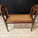 Louis XVI bench in walnut with cane seating.