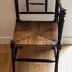 Corner chair made of turned wood with a straw seat.