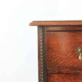 Antique oak chest of drawers on castors with brass handles and carved details