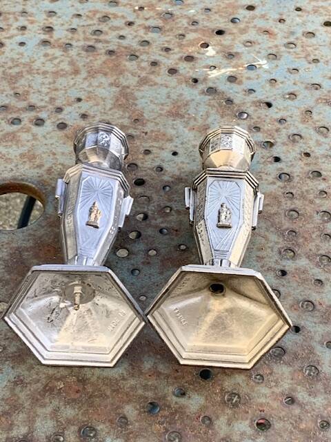 Pair of metal candlesticks, chiseled with a statuette in front, rose pattern in relief, art deco