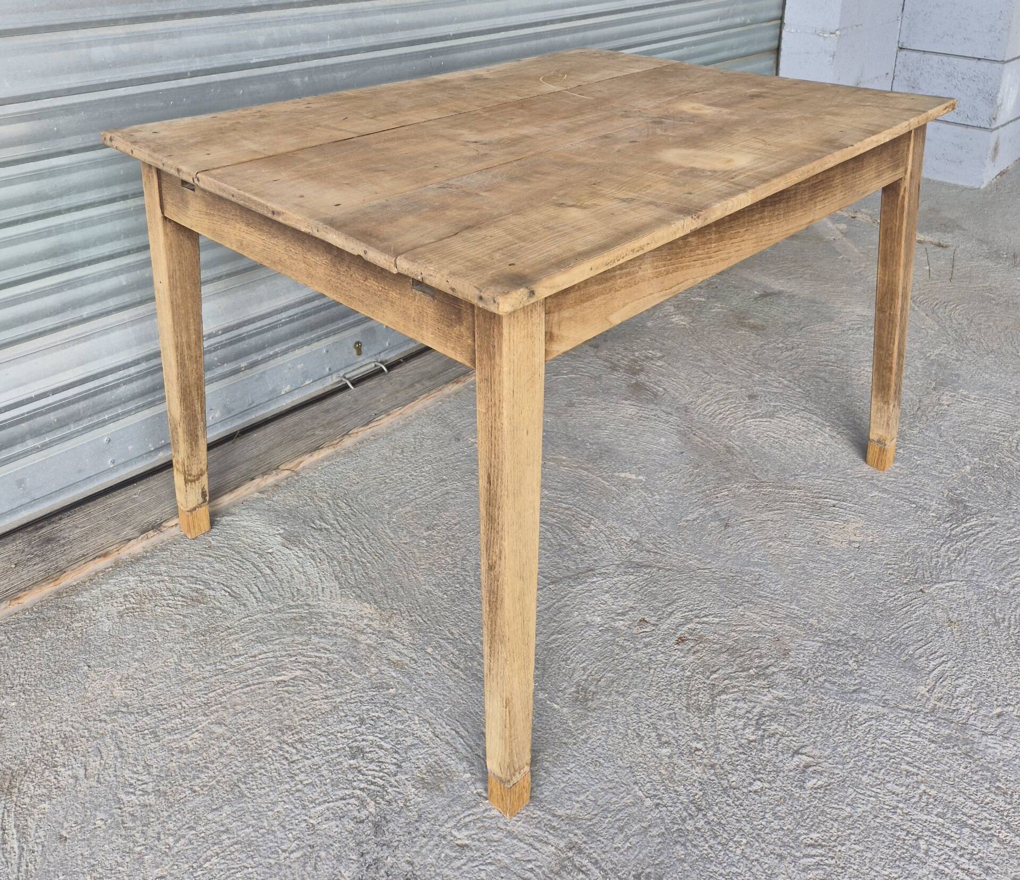 Old farmhouse table with its 2 extensions and raised legs.