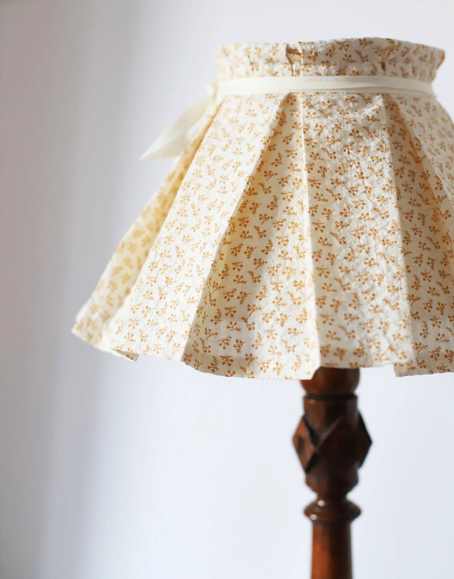 Lampe à poser, pied en bois sculpté et abat-jour plissé