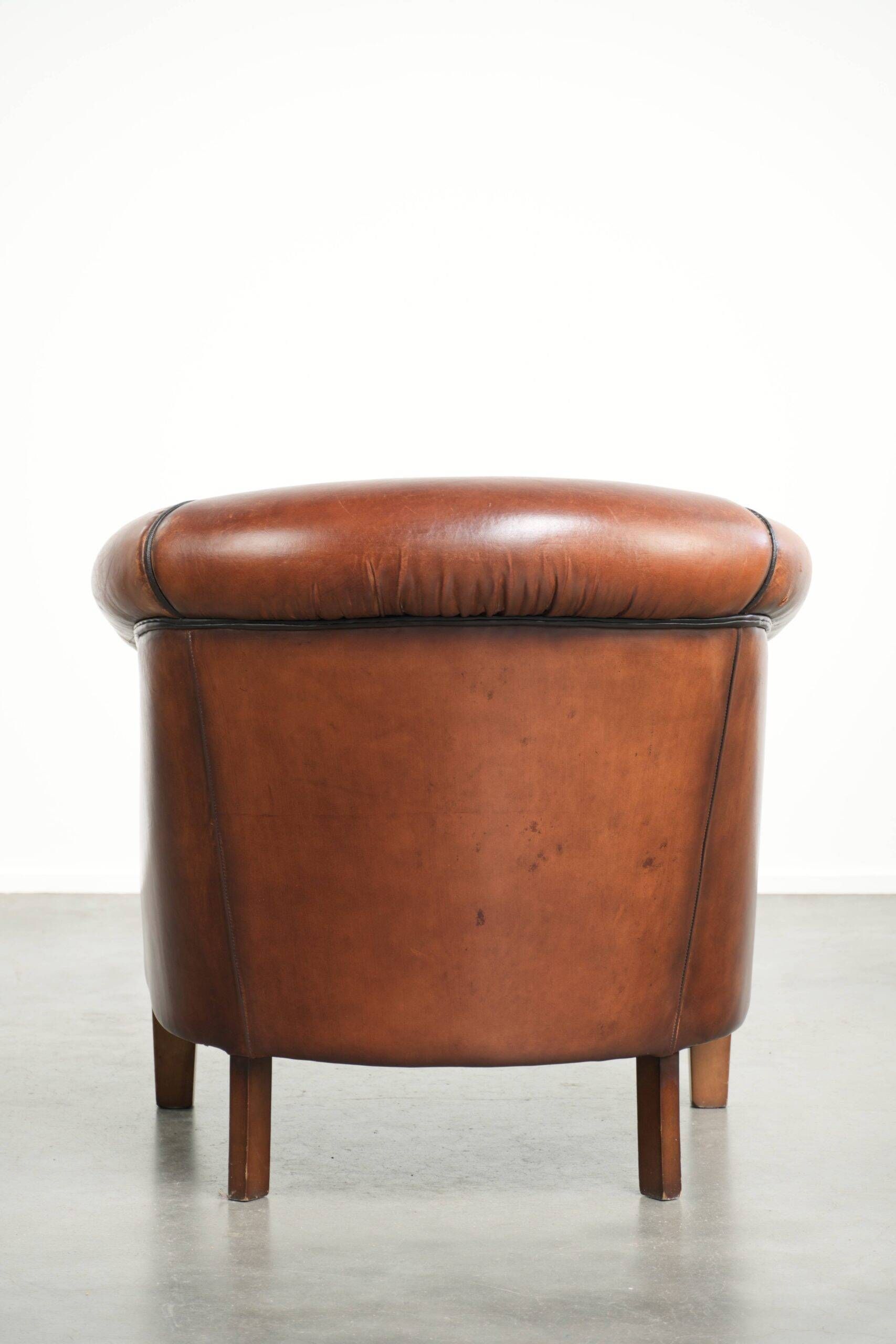 Vintage sheepskin club armchair finished with black piping
