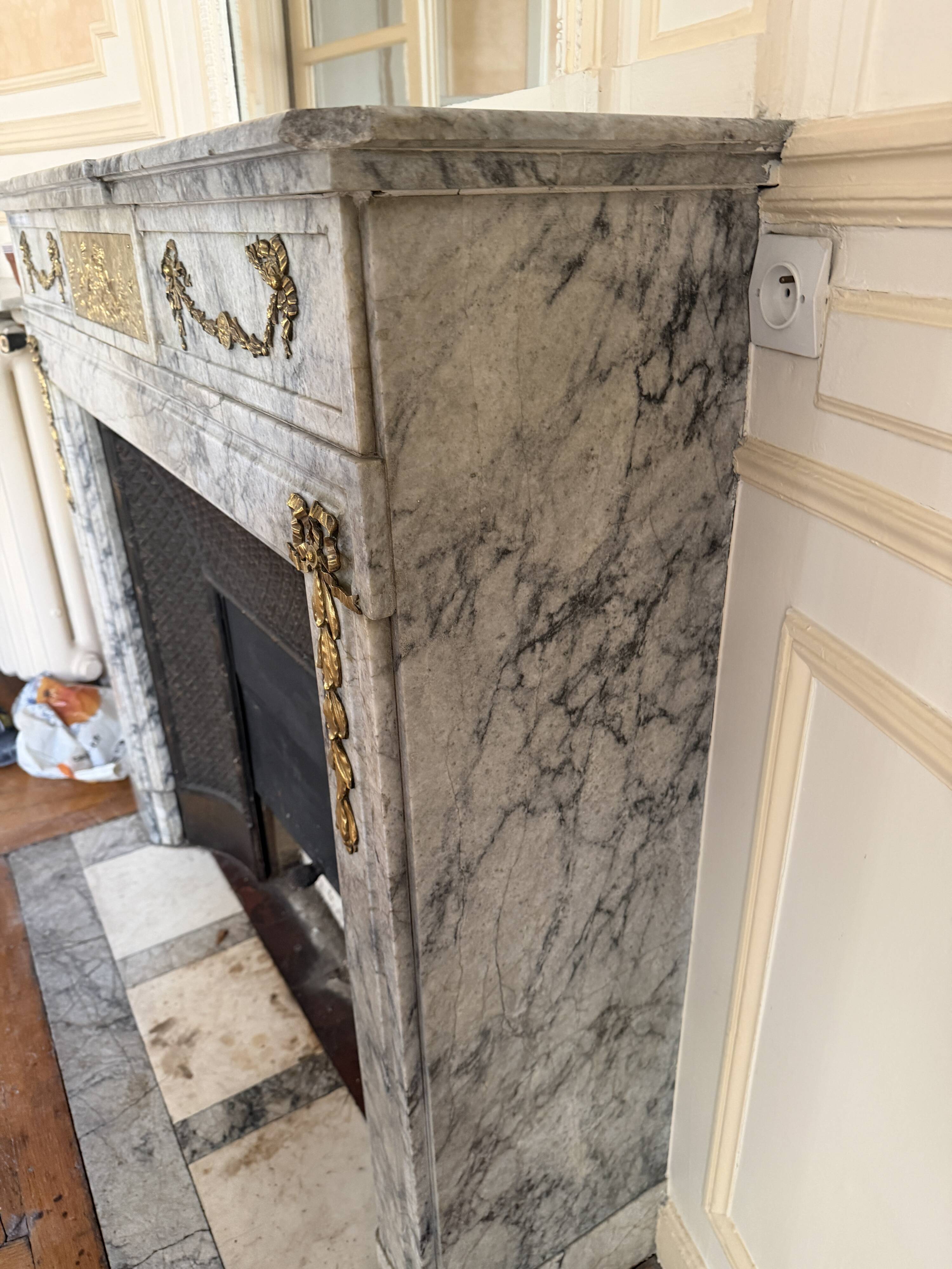 Louis XVI fireplace in veined grey marble with original gilded bronzes from the 19th century.
