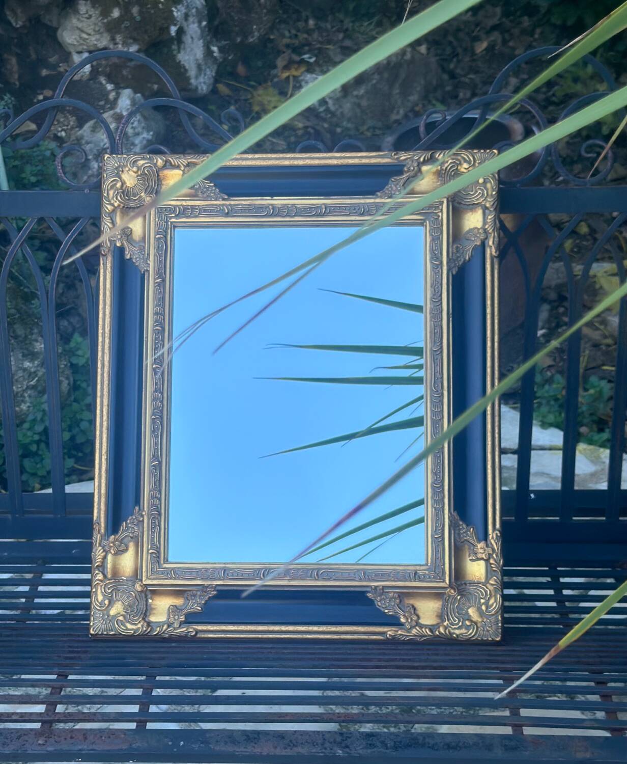 Baroque mirror in gilded wood on a black background.
