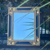 Baroque mirror in gilded wood on a black background.