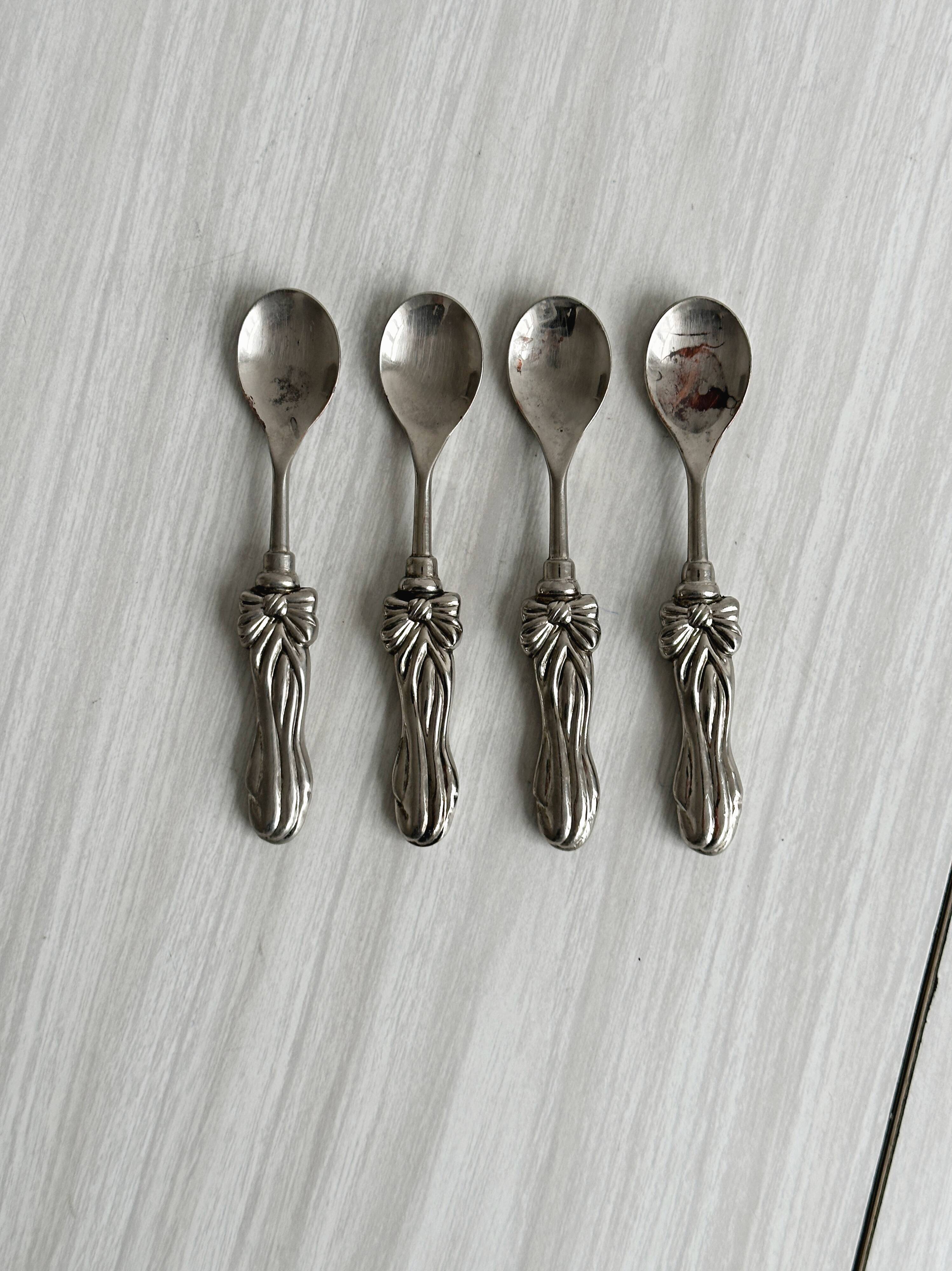 Antique small spoons with a metal bow design