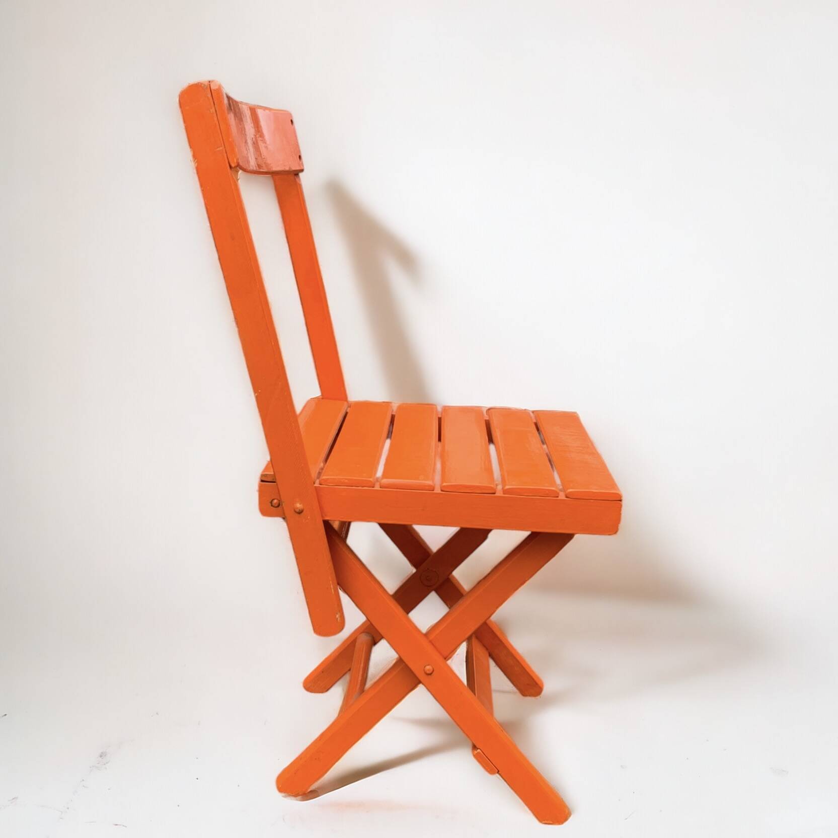 Vintage folding chair in orange painted wood