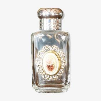 Bottle of white perfume with a capsule of roses on the front