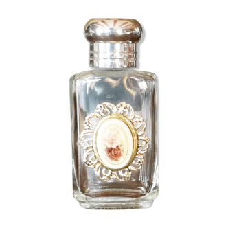 Bottle of white perfume with a capsule of roses on the front