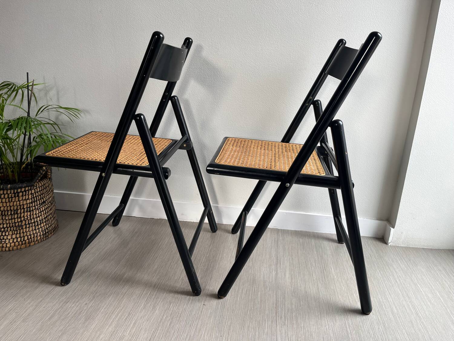 Vintage folding chairs in black wood and cane.