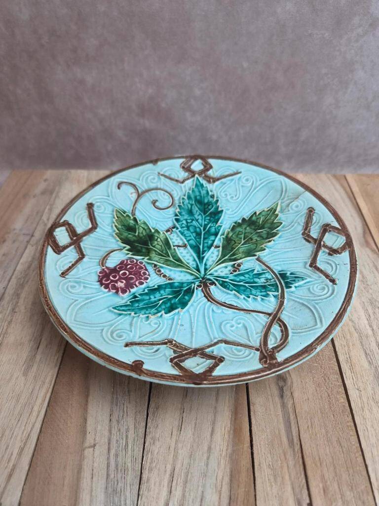 Old small compote dish in turquoise majolica with raised floral decoration.