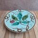 Old small compote dish in turquoise majolica with raised floral decoration.