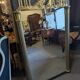 Large Empire-style mirror in dark green painted wood and gilded stucco.