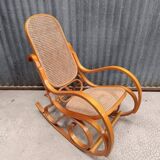 Curved wooden rocking chair with wicker cane rattan.