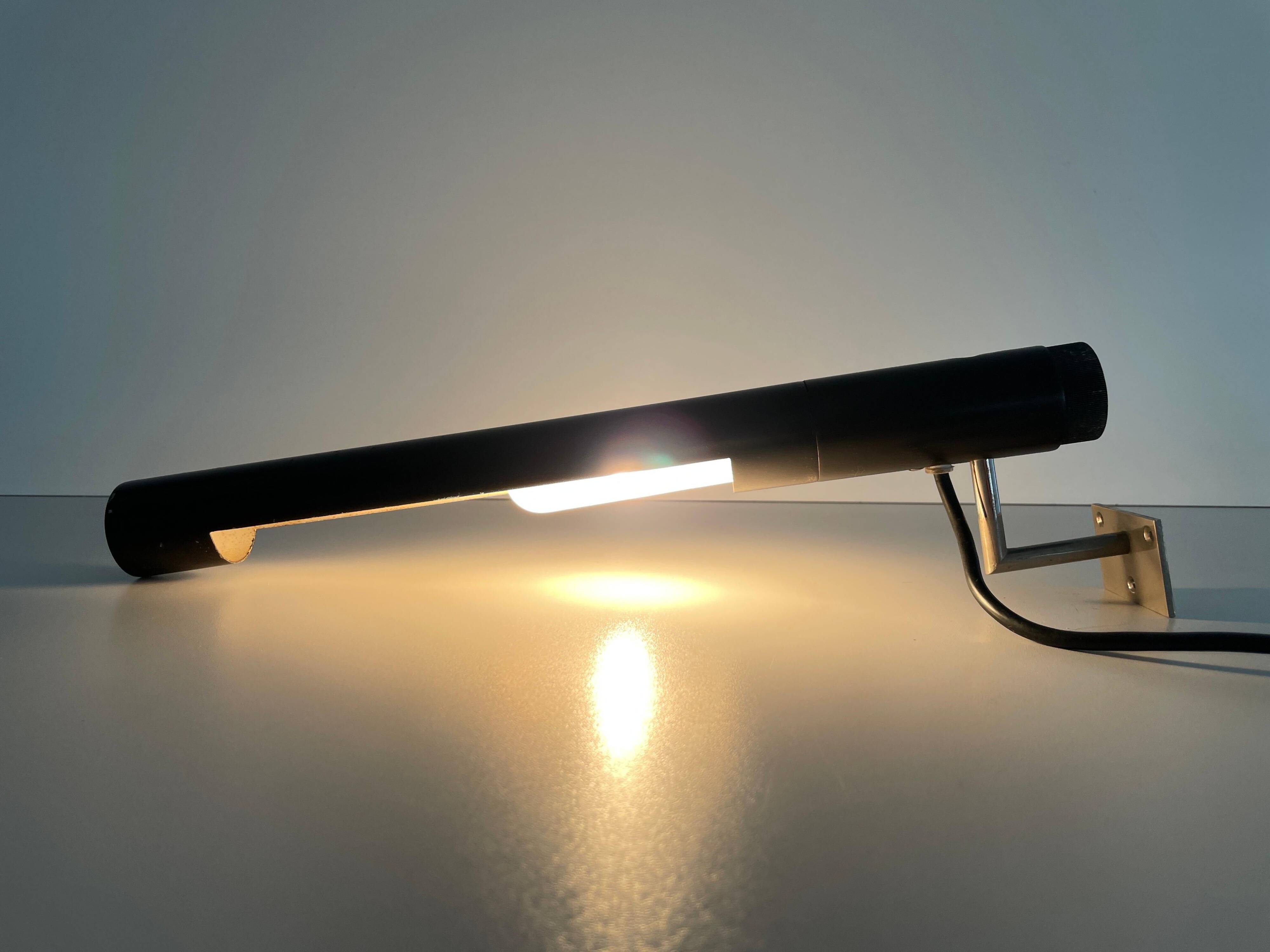Minimalist black metal wall light with a cylindrical design, 1960s, Germany.