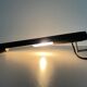 Minimalist black metal wall light with a cylindrical design, 1960s, Germany.