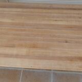 Large natural wood table with rectangular top supported by legs