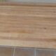 Large natural wood table with rectangular top supported by legs