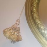 Oval mirror in wood and gilded plaster with pompom decoration