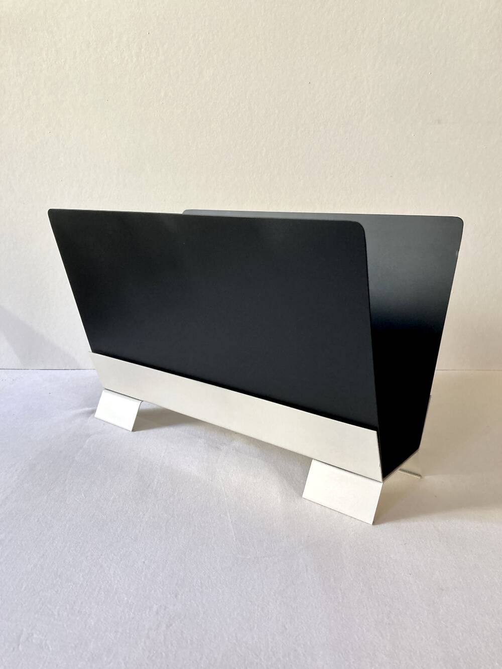 Black and cream metal magazine rack, 1950s.