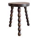 Small wooden tripod stool with turned legs, country style.