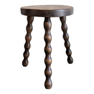 Small wooden tripod stool with turned legs, country style.