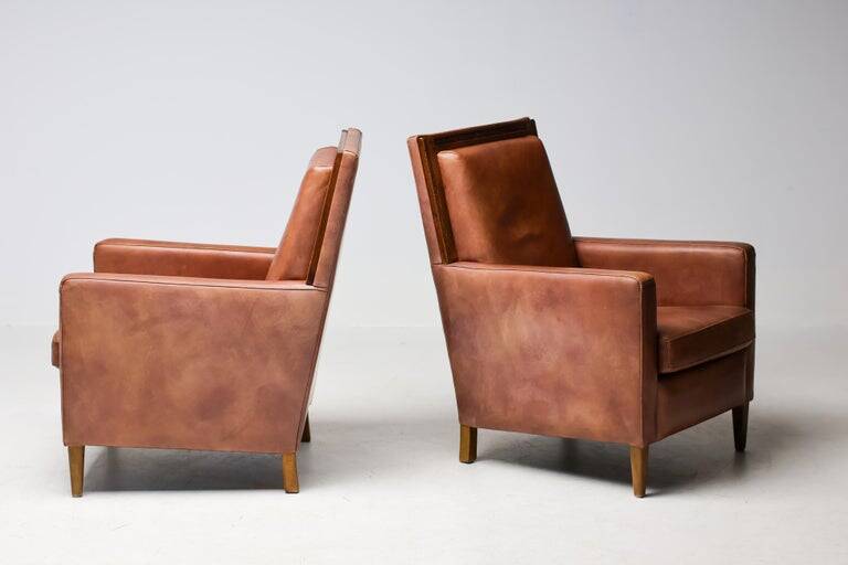Pair of Art Deco armchairs in brown leather and teak, Netherlands, 1970s.