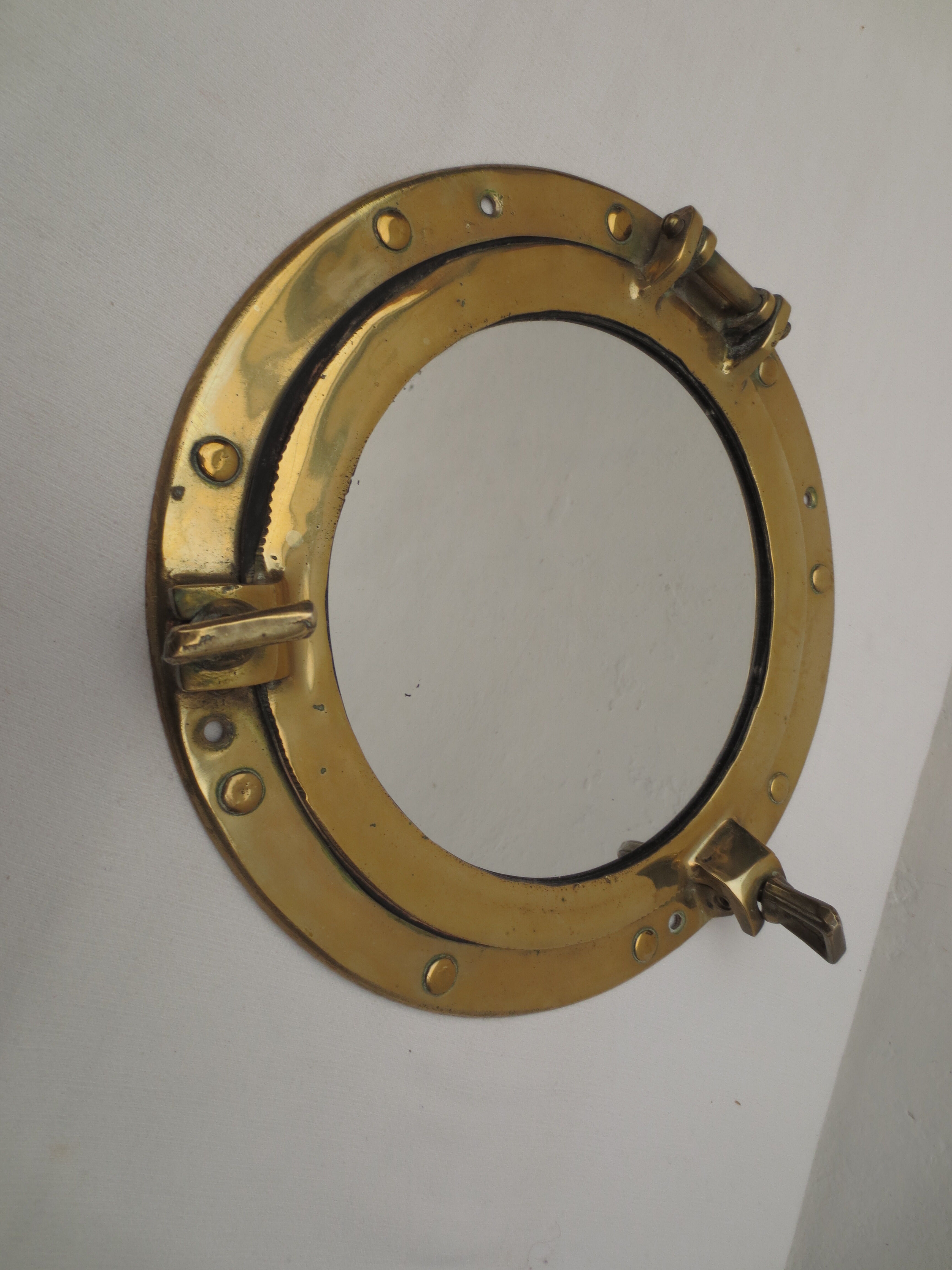 Mirror integrated into a brass navy porthole
