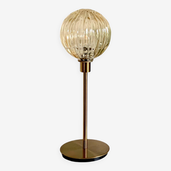 Table lamp with a gold striped globe and a gold foot