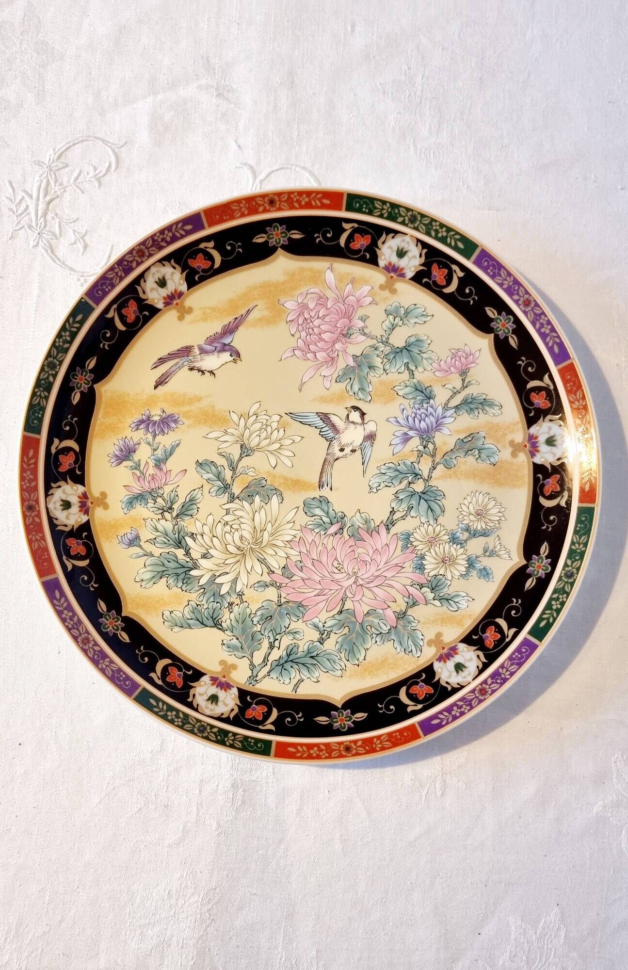 Vintage Japanese decorative plate with chrysanthemum and bird patterns.